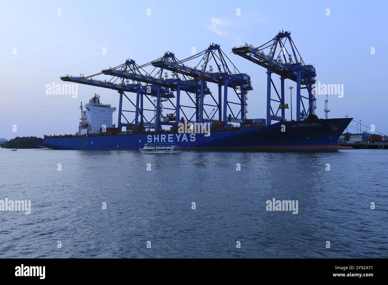 Terminal container industriale con una grande nave da carico e gru, che illustra il commercio globale e la logistica marittima Foto Stock