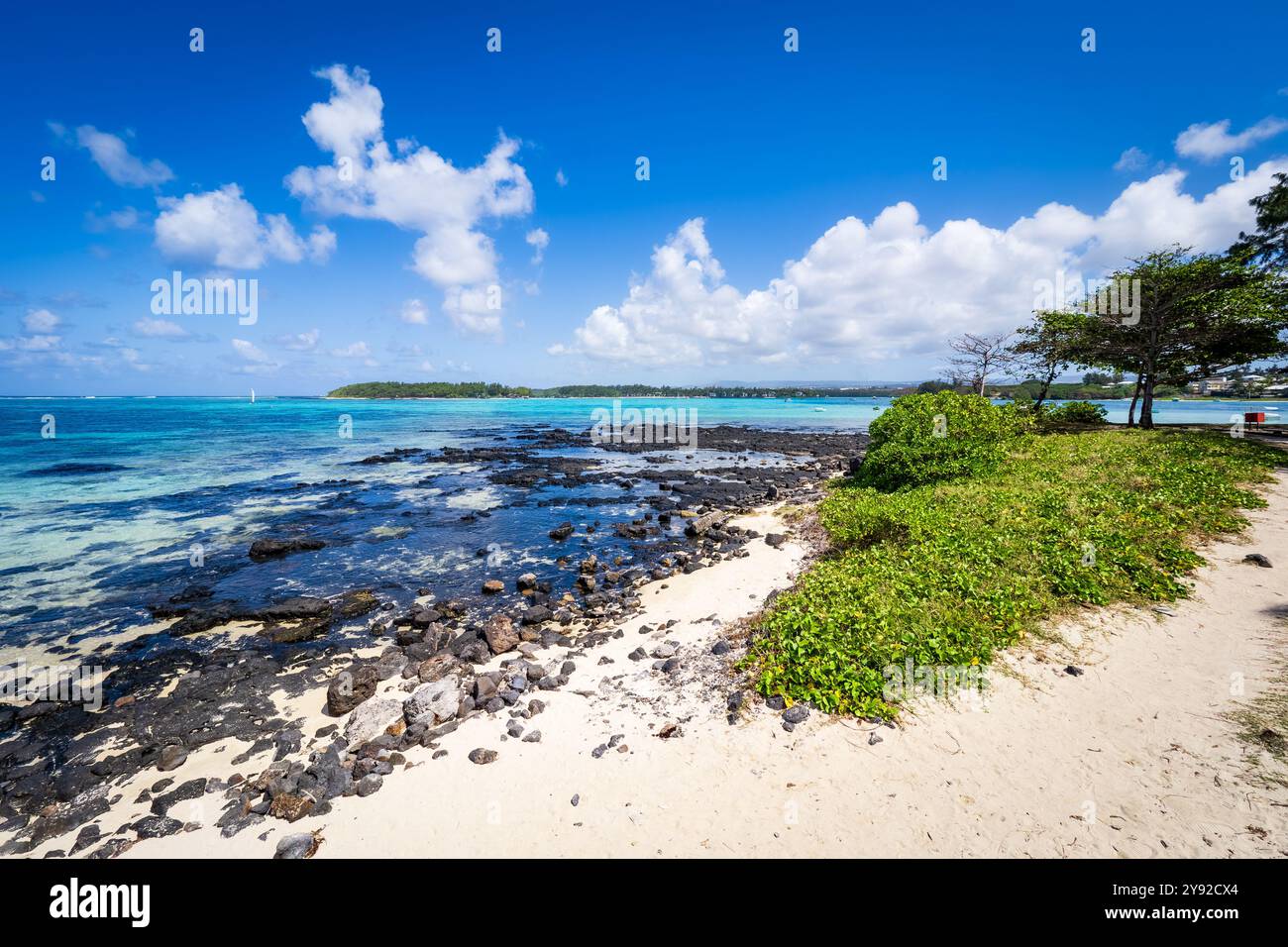 Splendida vista da cartolina di una spiaggia tropicale a Blue Bay, Mauritius, con barriere coralline visibili nelle acque cristalline e turchesi Foto Stock