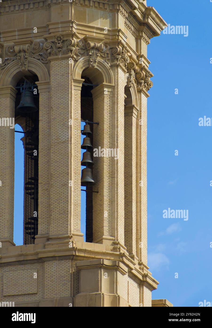 Un alto edificio con un campanile e un cielo blu. La torre è fatta di mattoni e ha una campana in cima. Particolare della Basilica di El Pilar Foto Stock