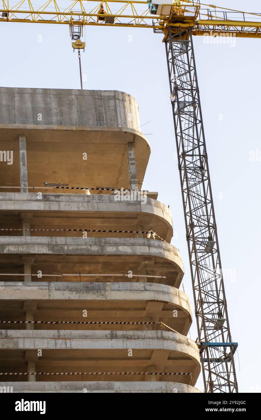 Un vivace cantiere con diverse gru in azione e un edificio significativo attualmente in costruzione, che mostra grandi progressi Foto Stock