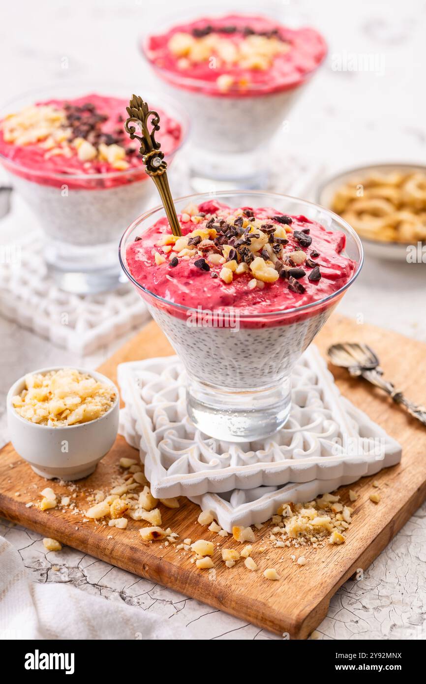 Budino di noci di cocco con frullato di lamponi, noci e pennini di cacao Foto Stock
