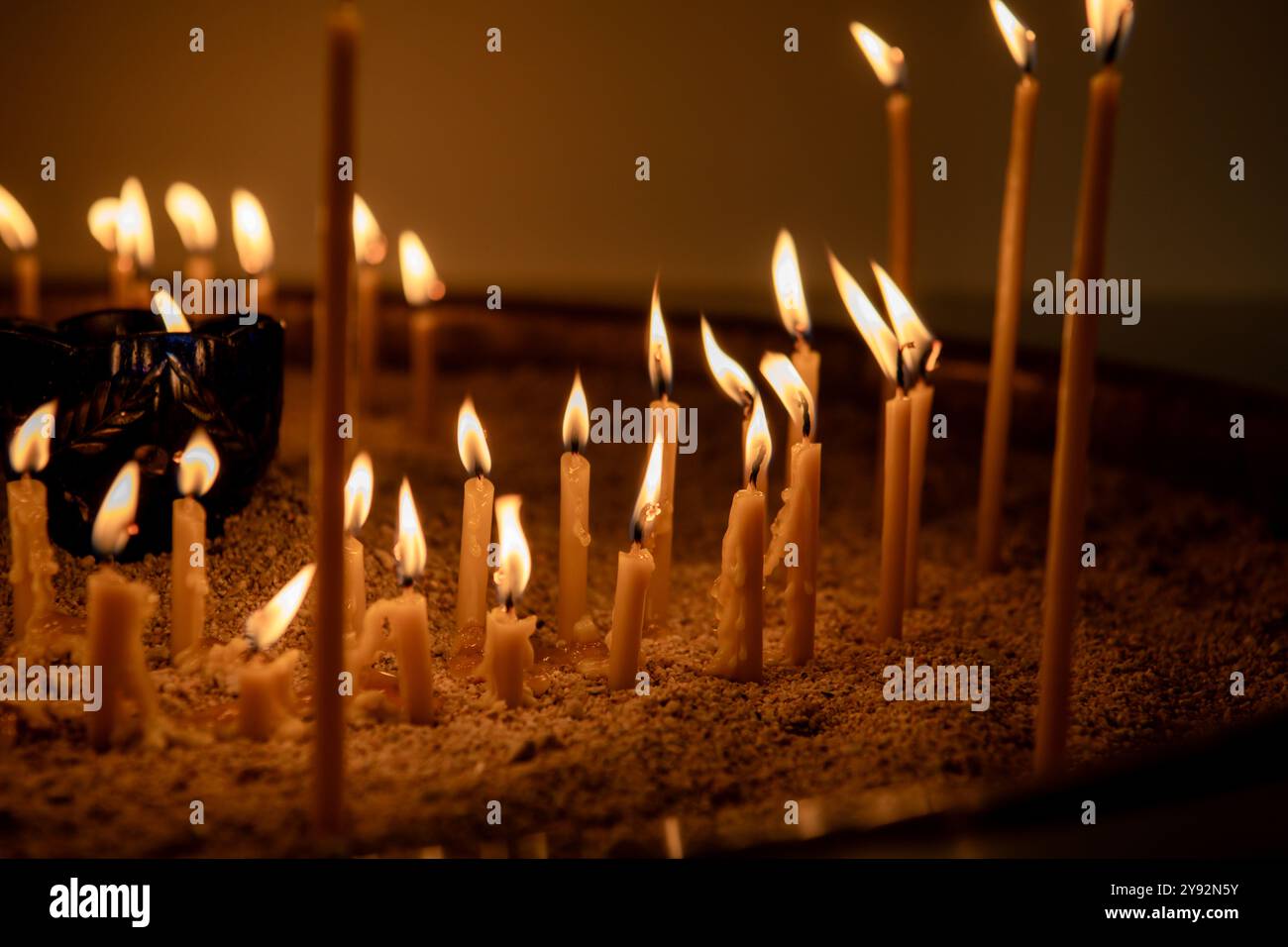 Bruciare le candele al buio. Profondità di campo ridotta. molte candele bruciate, tutto il giorno dell'anima, lume di candela Foto Stock