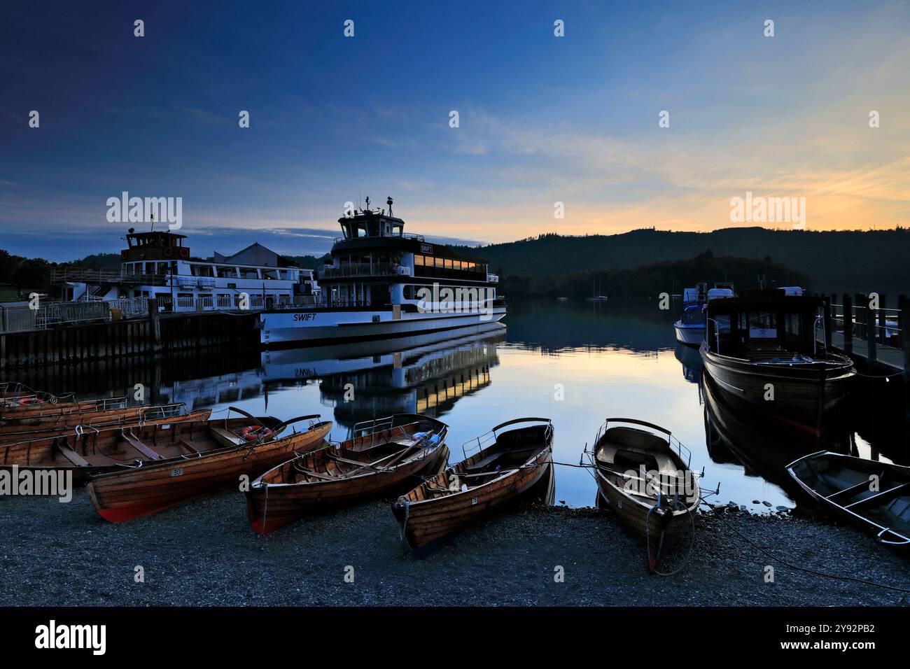 Tramonto sulle barche da diporto sul lago Windermere, Bowness sulla città di Windermere, Cumbria, Lake District National Park, Inghilterra, Regno Unito Foto Stock