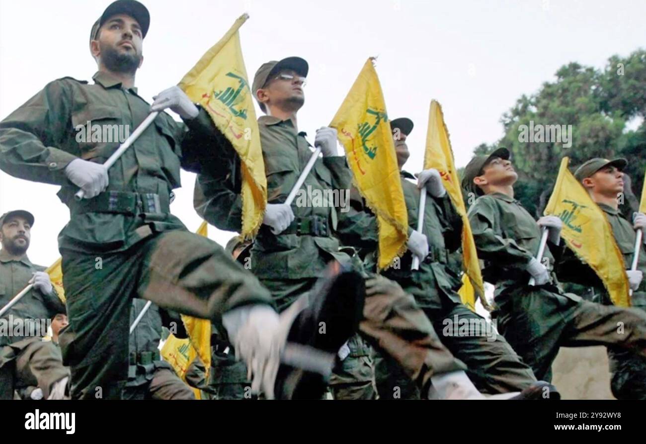 COMBATTENTI HEZBOLLAH sfilano nei sobborghi di Beirut il giorno del Martire, 11 novembre 2009. Essi detengono la bandiera nazionale del Libano e la bandiera gialla del gruppo sciita libanese. Foto: HMC Foto Stock