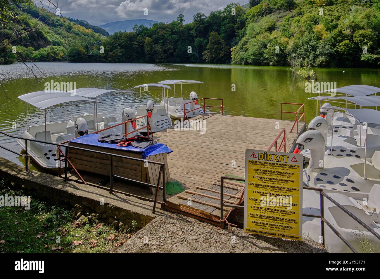 Lago di sera Gölü (lago Trabzon) a Trabzon, Turchia, vista della luce del giorno con persone in barca e ristoranti sullo sfondo. Foto Stock