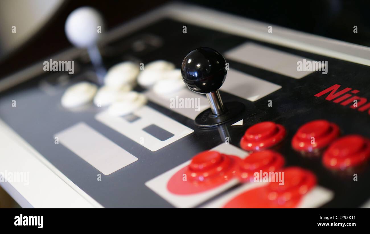 Primo piano di un classico joystick arcade e dei pulsanti su una console di gioco, che catturano l'essenza del gioco rétro e della nostalgia Foto Stock