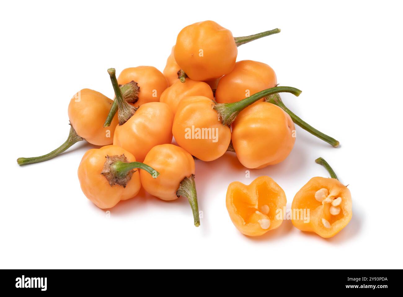 Un mucchio di peperoni crudi freschi di Peacha Dew e uno tagliato a metà davanti, isolato su sfondo bianco Foto Stock