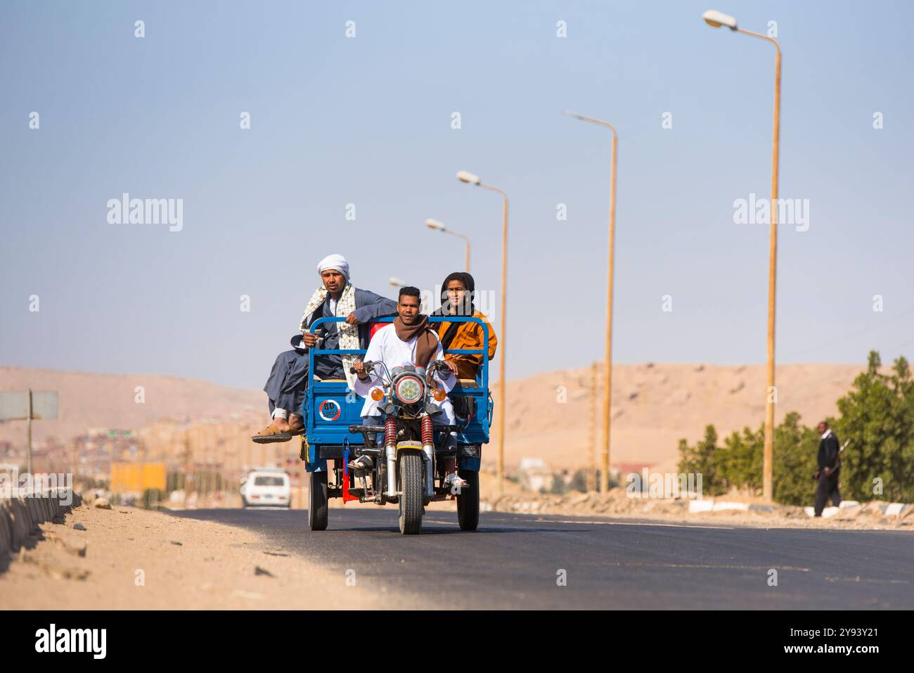 La famiglia viaggia su un triciclo motorizzato verso un villaggio sul Nilo vicino alla Necropoli di El-Kab, sulla riva orientale del Nilo, Egitto, Nord Africa Foto Stock