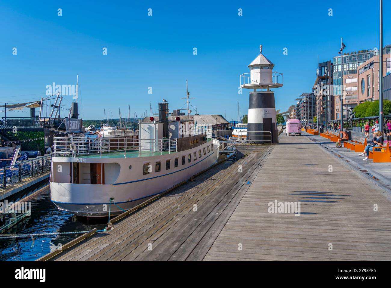 Vista del faro di Oslo e dei caffè sul lungomare, Aker Brygge, Oslo, Norvegia, Scandinavia, Europa Foto Stock