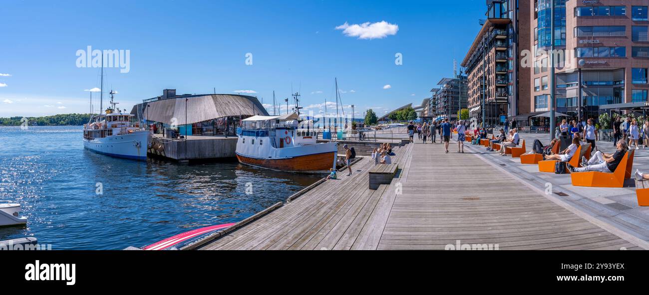 Vista della barca e dei lettini sul lungomare, Aker Brygge, Oslo, Norvegia, Scandinavia, Europa Foto Stock