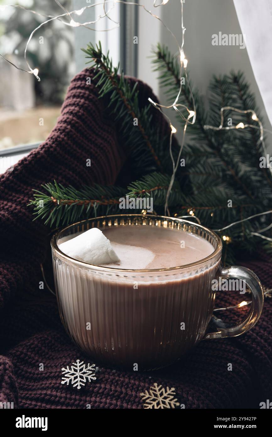 Accogliente natura morta natalizia con cioccolata calda, rami di abete e luci. Foto Stock