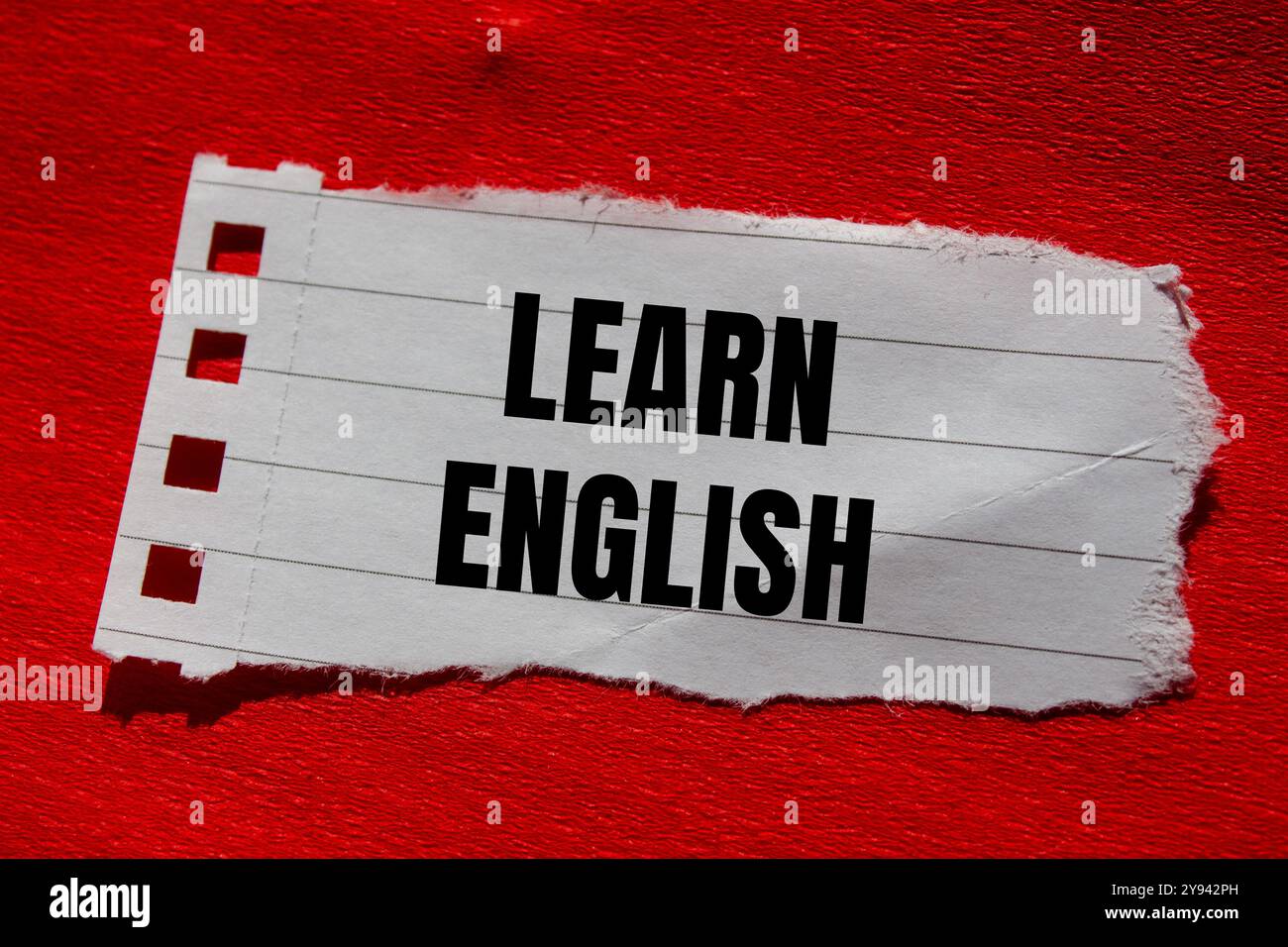 Impara il messaggio in inglese scritto su un pezzo di carta strappato con sfondo rosso. Simbolo Impara l'inglese concettuale. Copia spazio. Foto Stock