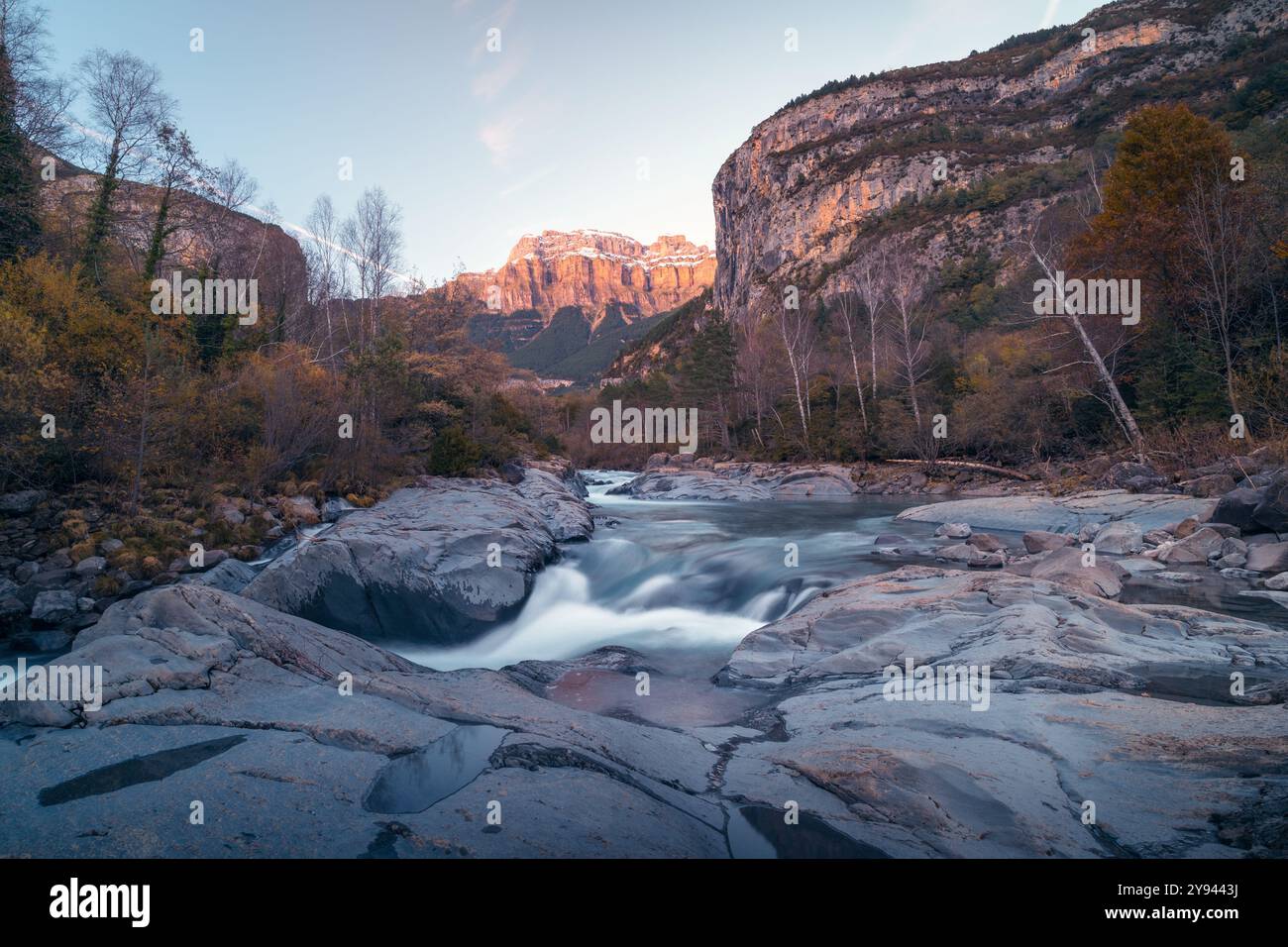 L'autunno trasforma i Pirenei Aragonesi in una tela di colori vivaci lungo il fiume Ara, che presenta acque tranquille e aspre scogliere boscose Foto Stock