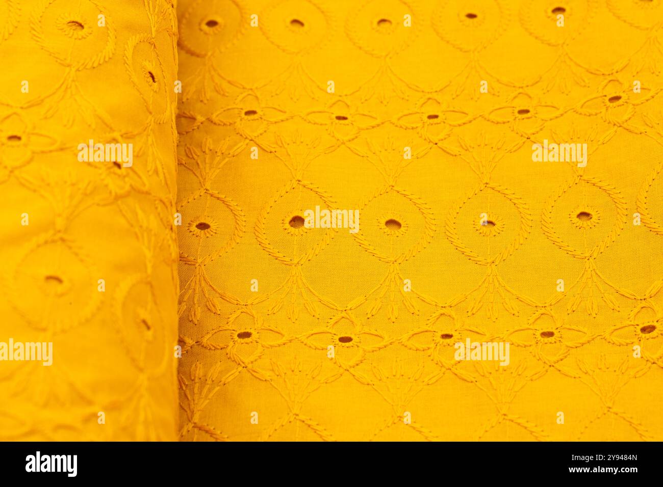 Tessuto giallo brillante con un intricato motivo circolare per ricami, perfetto per i progetti estivi e creativi in tessuto Foto Stock