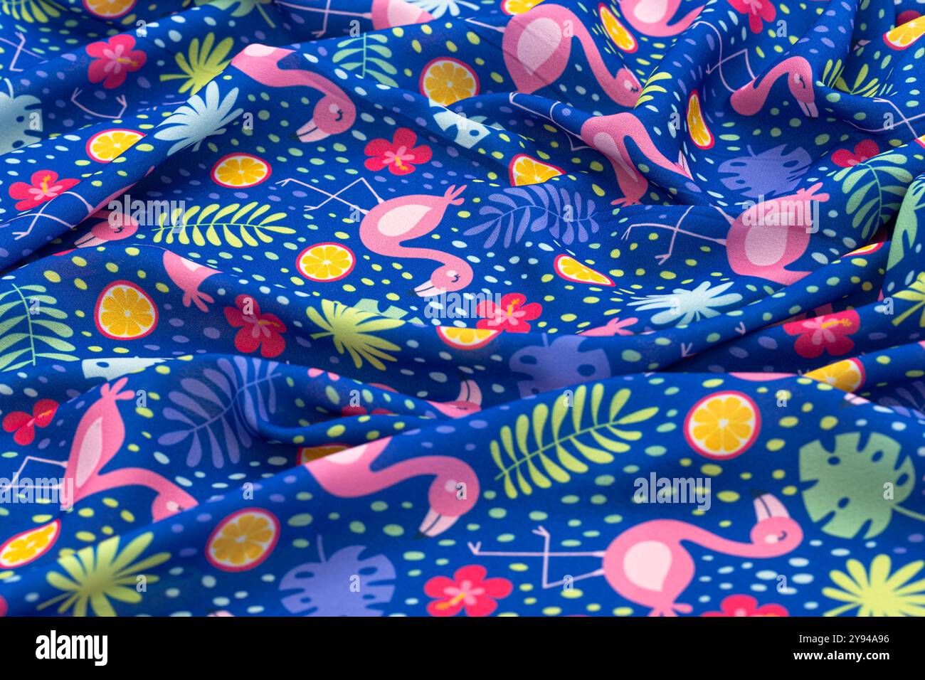 Luminoso motivo in tessuto fenicottero tropicale con fenicotteri rosa, agrumi e foglie tropicali su sfondo blu Foto Stock