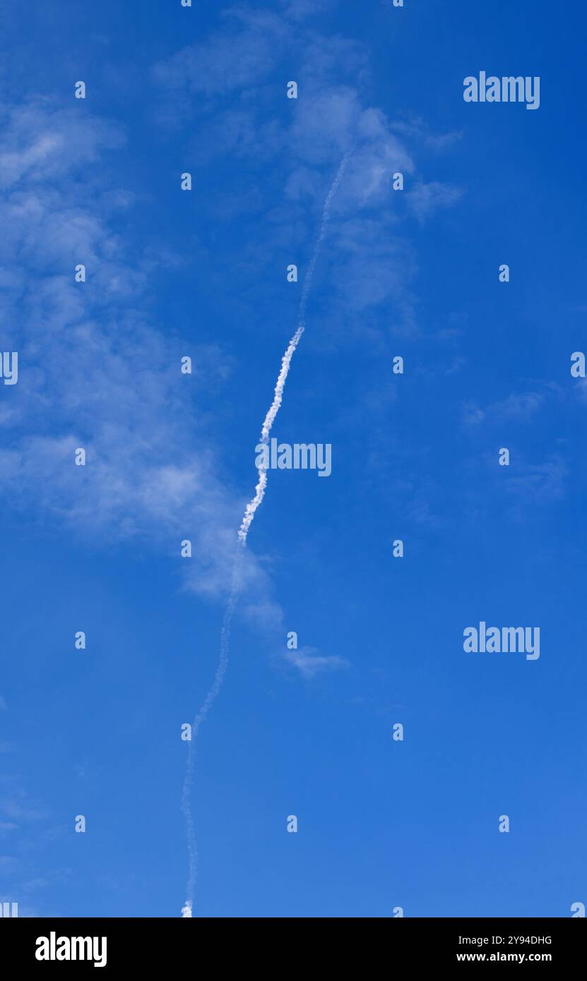 Blue Sky con White Tracer Missile Trail sopra gli edifici della città durante le operazioni di razzo militare Warzone Atmosphere Defense Action Aerial Combat Urban W. Foto Stock