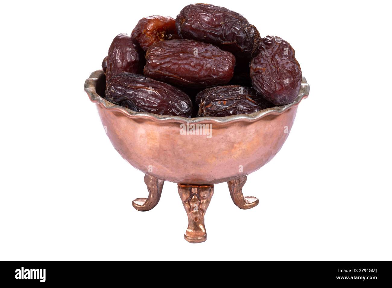 Una ciotola di datteri Medjool freschi e sontuosi in una ciotola vintage in rame con dettagli intricati Foto Stock