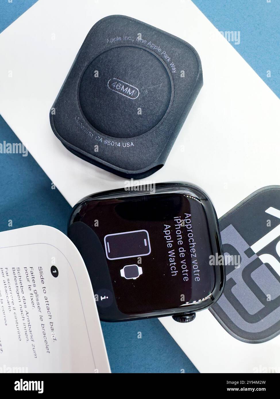 Confezione con la nuova configurazione dello smartwatch Apple Watch serie 10 del 2024, unboxing e braccialetto intercambiabile su sfondo blu Design elegante - Immagine stock catturata con smartphone
