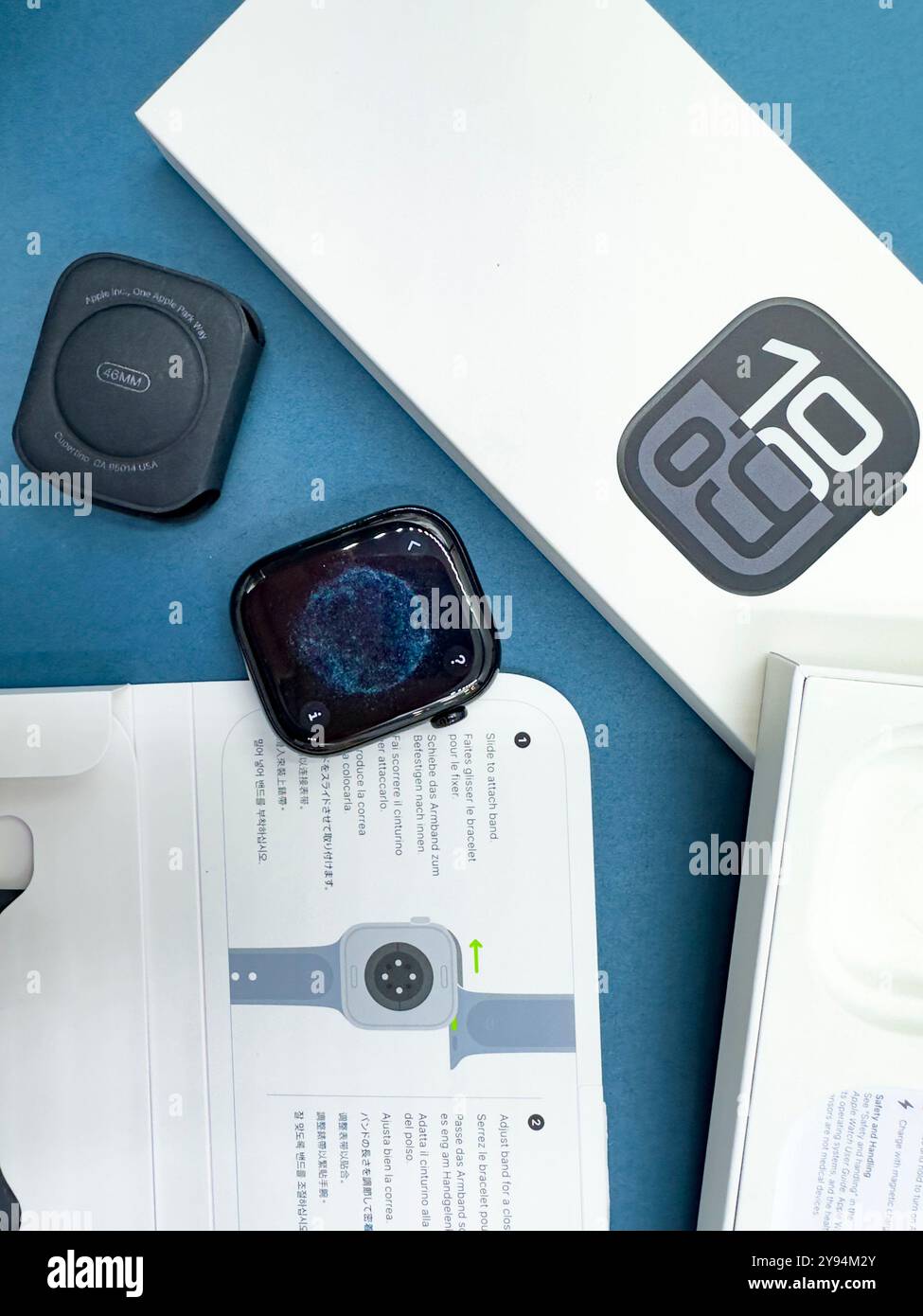 Confezione con la nuova configurazione dello smartwatch Apple Watch serie 10 del 2024, unboxing e braccialetto intercambiabile su sfondo blu Design elegante Foto Stock