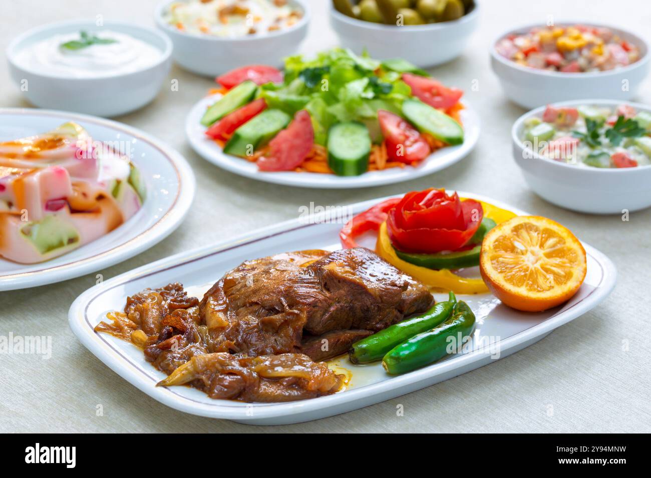 Stufato di agnello in stile persiano con cipolle caramellate e insalata fresca, guarnita con erbe e agrumi. Foto Stock