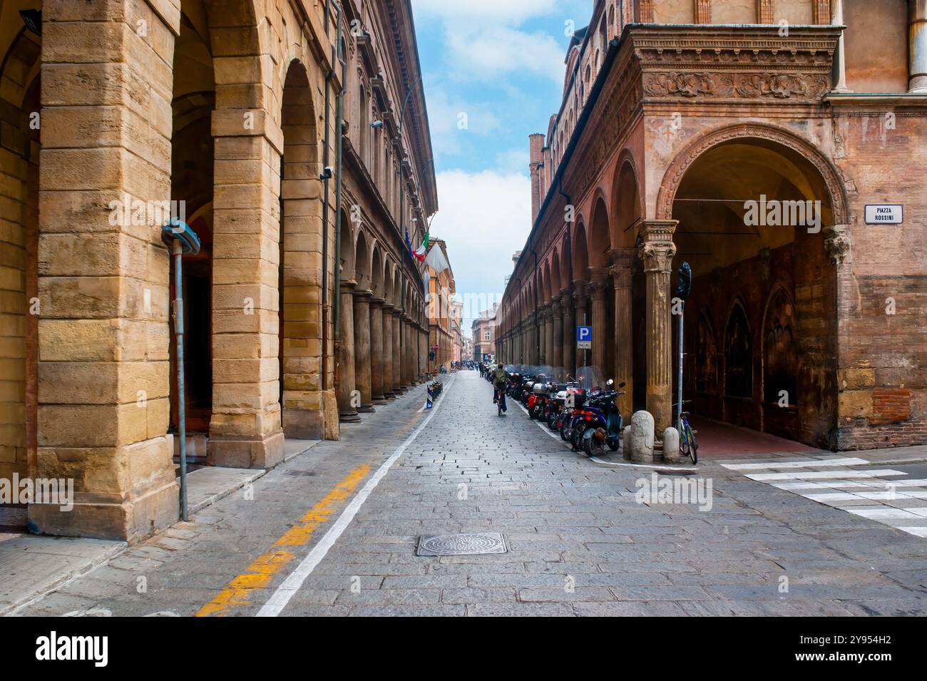 Via Zamboni con biciclette parcheggiate lungo i portici della Basilica di San Giacomo maggiore, Bologna, Italia Foto Stock