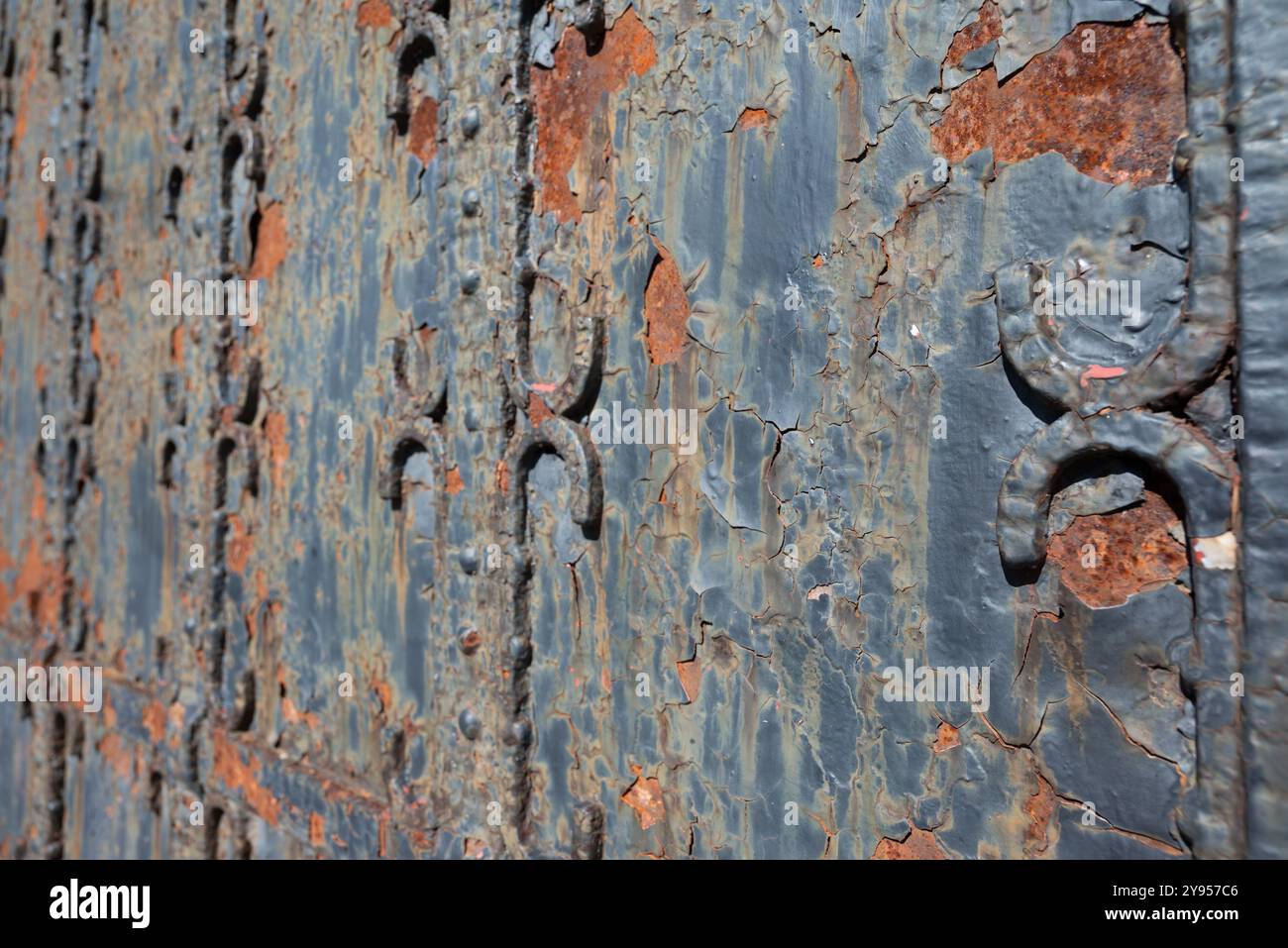 Punto di iniezione in ferro arrugginito con una superficie molto usurata. Questa immagine macro di primo piano è adatta per essere utilizzata come sfondo, mostrando le forature staccate dal ferro. Foto Stock