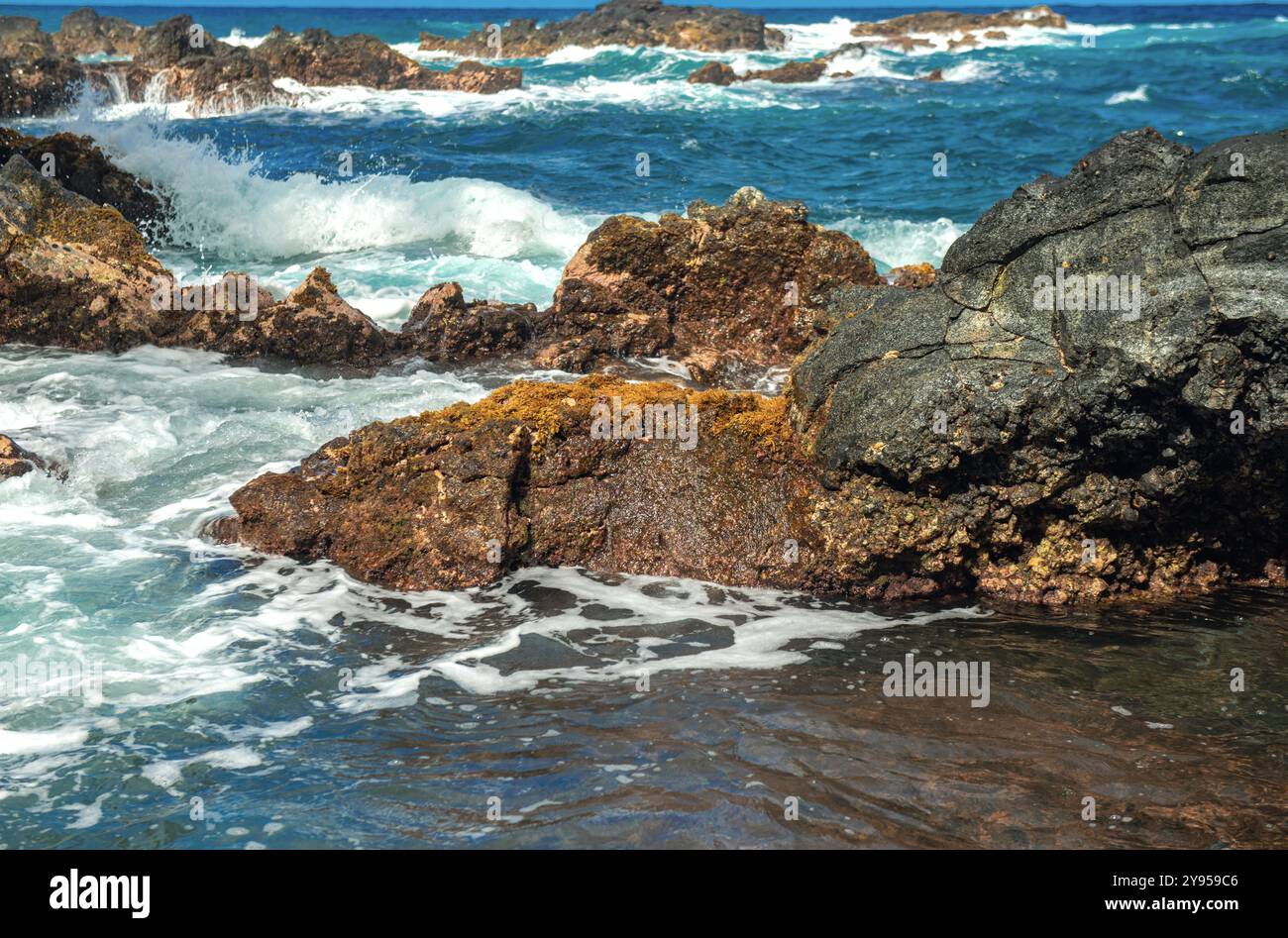 Sfondo mare. L'onda dell'oceano si schiantano sulla costa rocciosa con spruzzi e schiuma prima della tempesta. Foto Stock