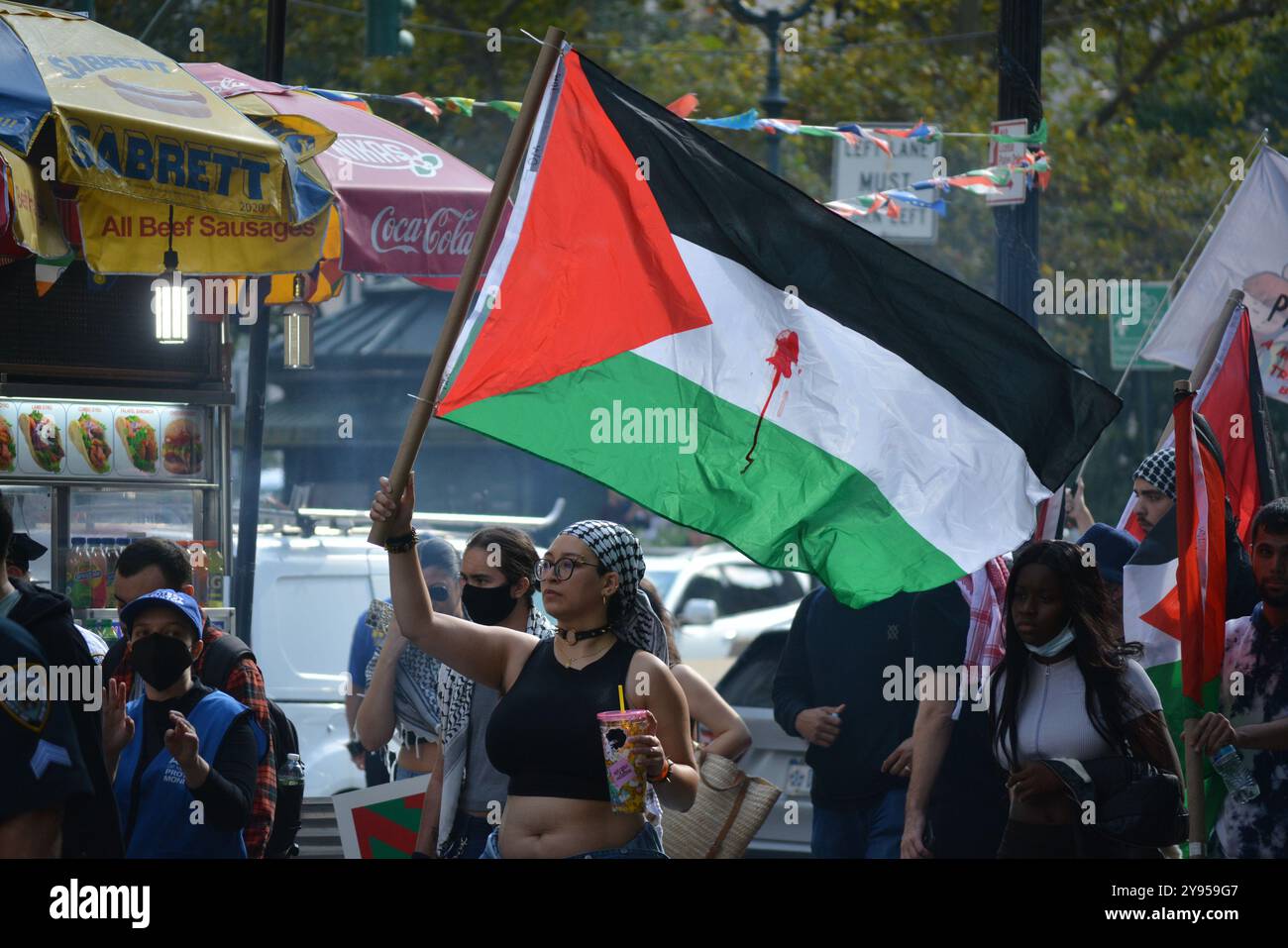 Persone con cartelli e bandiere durante una manifestazione pro Palestina nel primo anniversario degli attentati del 7 ottobre in Israele a New York. Foto Stock