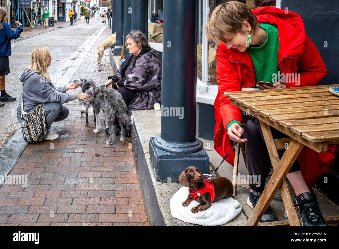 Gente del posto con i loro animali domestici seduti fuori Da Un Cafe in High Street, Lewes, East Sussex, Regno Unito. Foto Stock