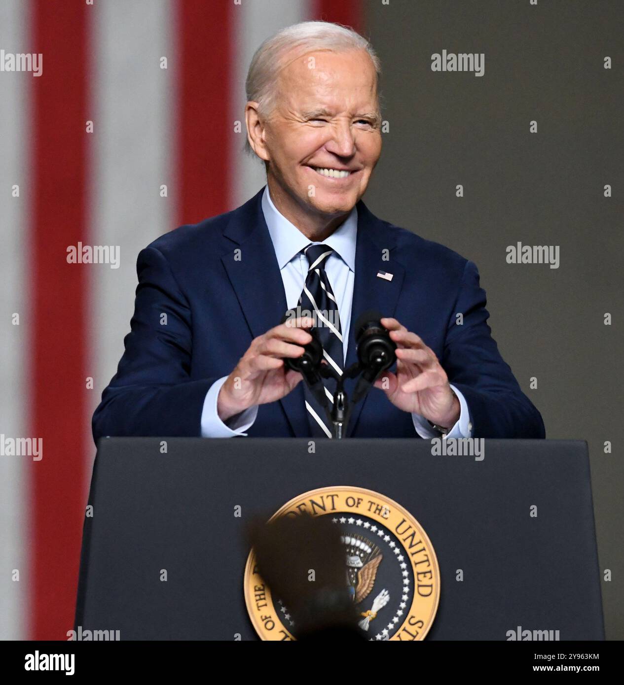 Milwaukee, Wisconsin, Stati Uniti. 8 ottobre 2024. Il presidente JOE BIDEN annuncia nuovi finanziamenti per la fornitura di acqua pulita e la sostituzione dei tubi di piombo a livello nazionale, fissando una scadenza di 10 anni per la sostituzione delle linee di servizio principali. Uno spettatore in primo piano solleva un pugno in sostegno. Biden ha parlato nel garage del Dipartimento dei lavori pubblici della città. (Credit Image: © Mark Hertzberg/ZUMA Press Wire) SOLO PER USO EDITORIALE! Non per USO commerciale! Foto Stock