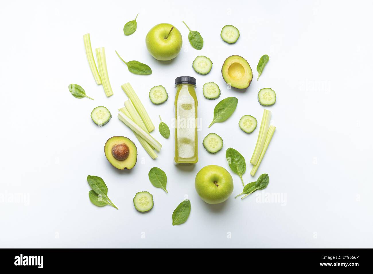 Bottiglia di frullato verde circondato da frutta e verdura verdi: Mele, avocado, spinaci, sedano, cetriolo su sfondo semplice bianco vi Foto Stock