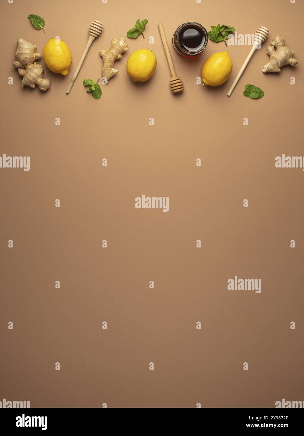 Composizione con limoni, menta, zenzero, miele in vaso di vetro e miele in legno a immersione vista dall'alto. Cibo per la stimolazione immunitaria e contro l'influenza stagionale. H Foto Stock