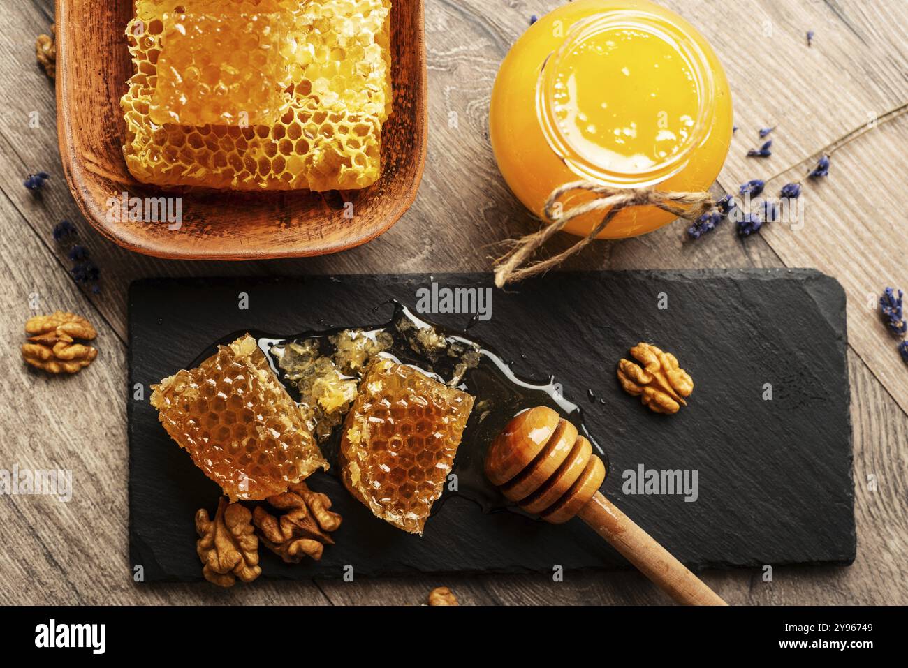 Nido d'ape su vassoio in ardesia con miele e noci sul tavolo della cucina, fotografia di cibo, fotografia di cibo Foto Stock