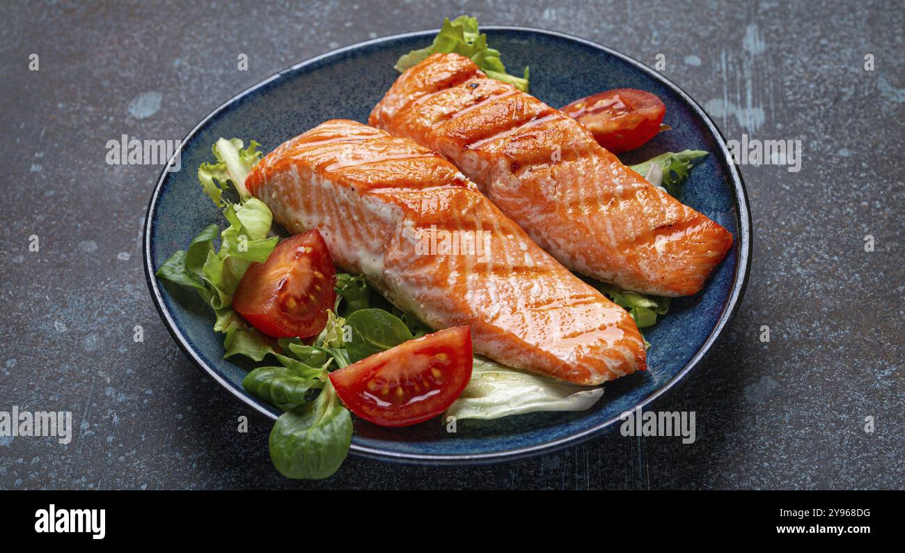 Carne di salmone alla griglia con insalata di verdure su piatto di ceramica su sfondo rustico, vista angolare, dieta bilanciata o pasto di insalata nutrizionale sana Foto Stock