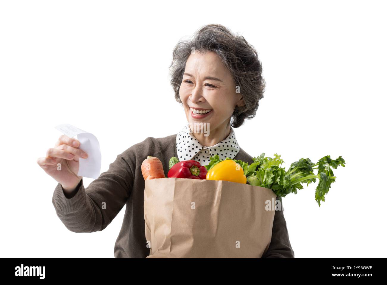 Donna anziana che tiene la spesa e la ricevuta Foto Stock