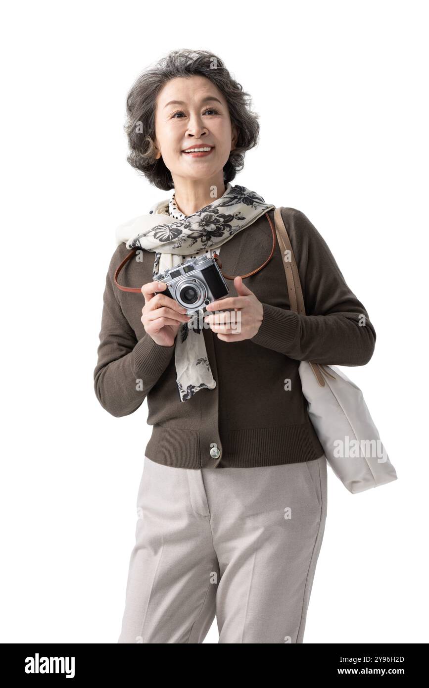 Donna anziana che scatta foto con una macchina fotografica Foto Stock