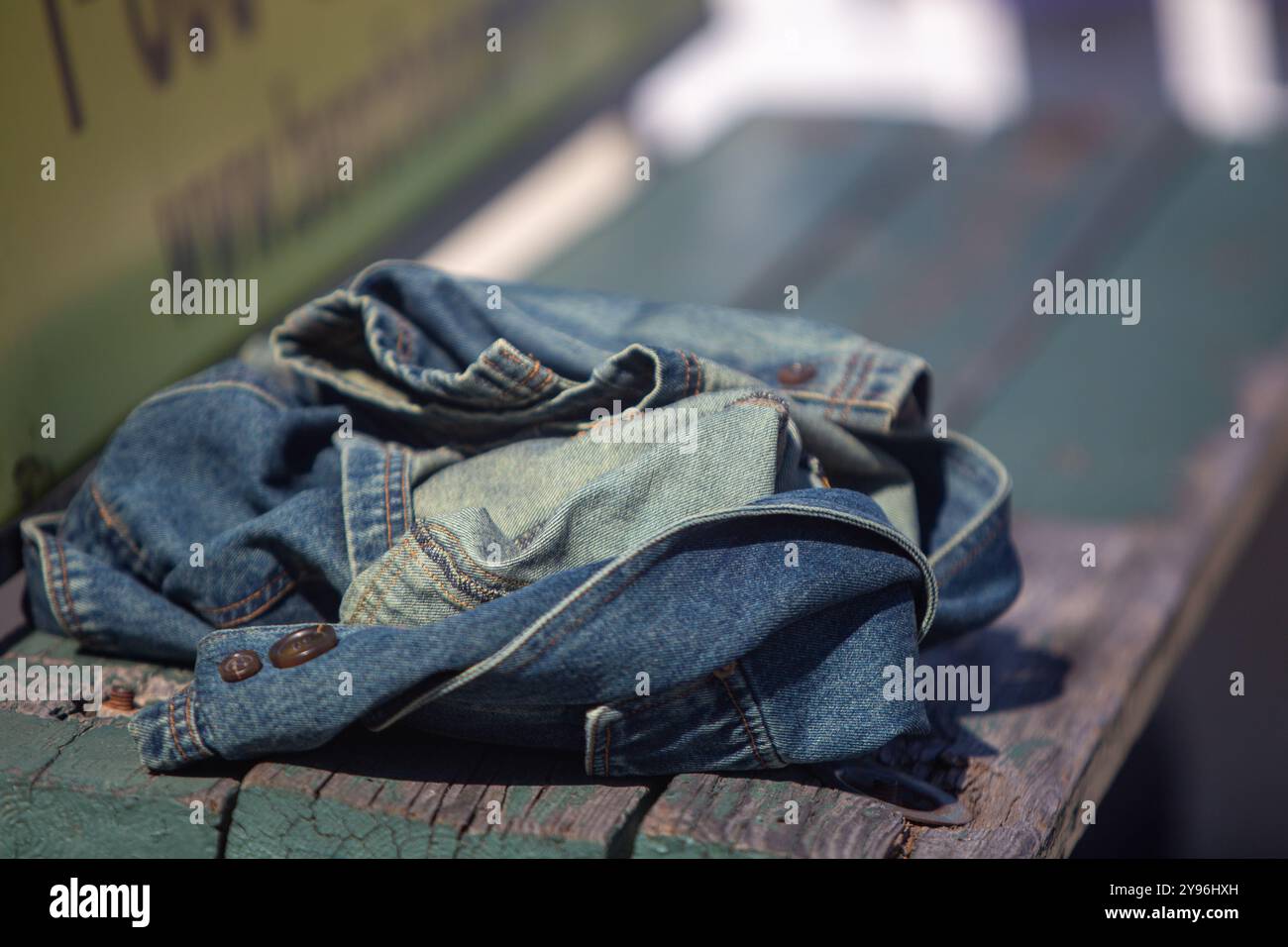 Jean Jacket lasciato su una panchina Foto Stock