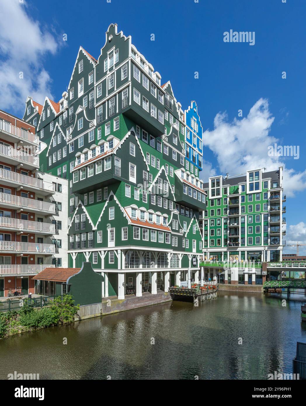 Zaandam, Paesi Bassi. 9 giugno 2024. Colorato Inntel Hotel a Zaandam, tradizionali case Zaanse in verde e blu e canale davanti. Foto Stock