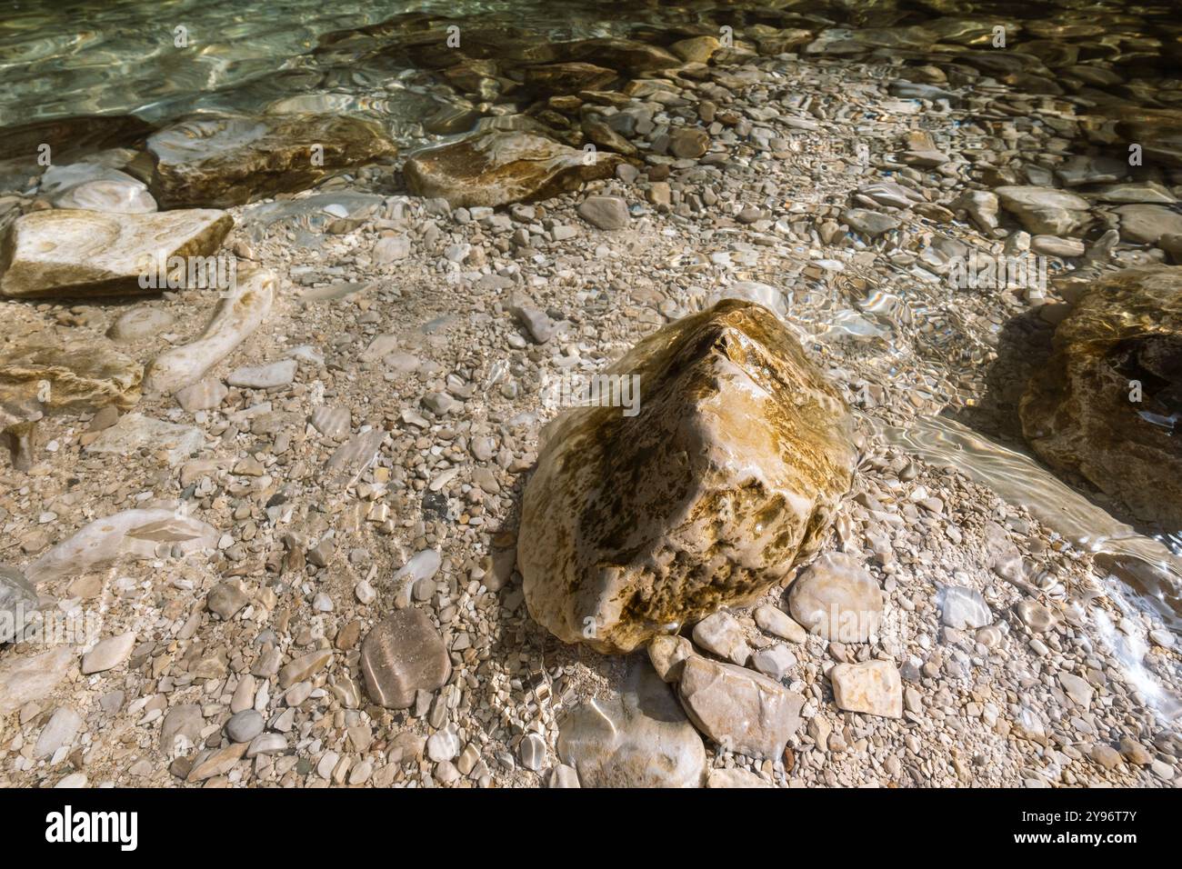 grande pietra circondata da acque cristalline del fiume di montagna Foto Stock