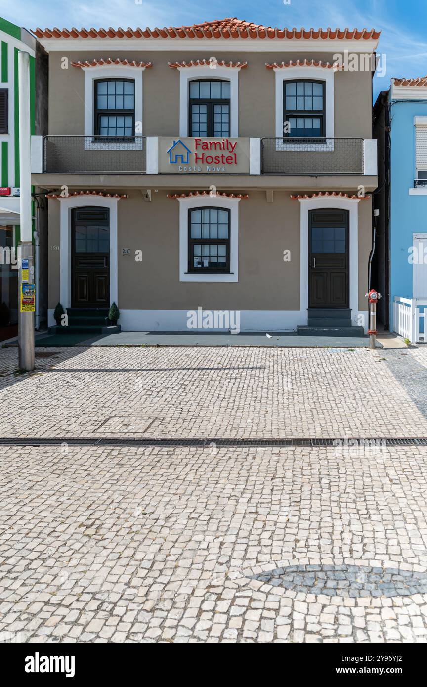 Costa Nova, Portogallo - 11 settembre 2024 : Un ostello di famiglia sorge su una strada acciottolata in una soleggiata cittadina costiera, fornendo riparo. Foto Stock