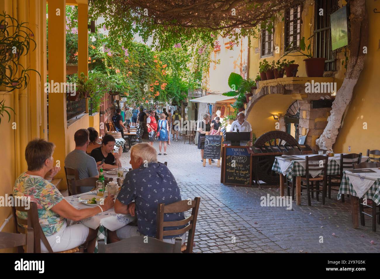 La città vecchia di Chania, vista della gente che pranza ai tavoli del ristorante situati in una strada nel pittoresco quartiere veneziano della città vecchia di Chania (Hania), Creta Foto Stock