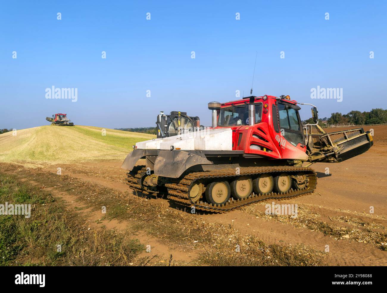 Veicoli bulldozer cingolati a pistoni con sistema di chiusura per insilato di granturco dolce nel campo immagazzinato per biocarburanti, Alderton, Suffolk, Inghilterra, Regno Unito Foto Stock