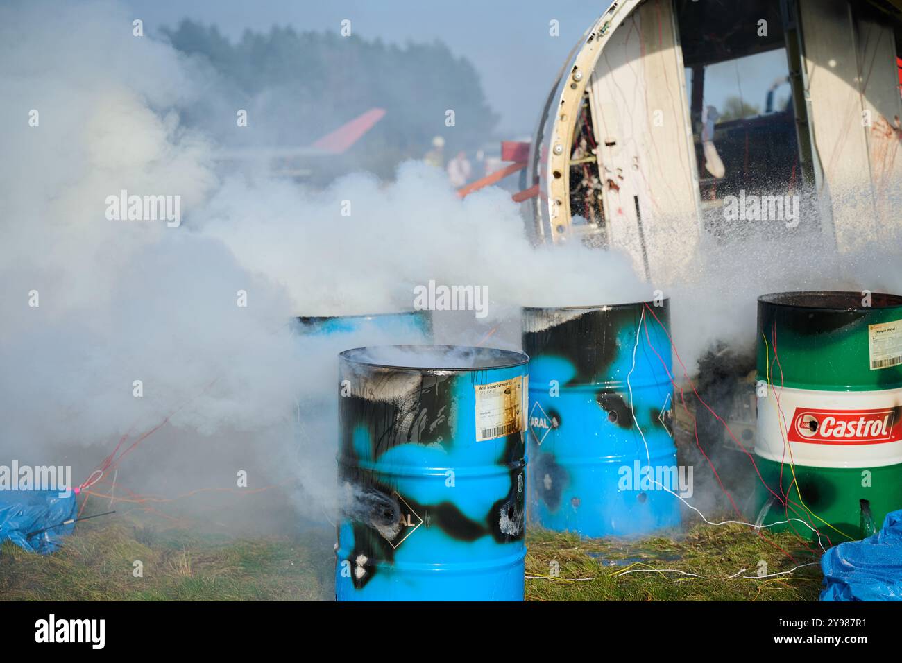 8 ottobre 2024, Berlino, Schönefeld: Un aereo naufragato e barili in fiamme si trovano su un prato per simulare un'operazione di salvataggio a seguito di un incidente aereo. I processi di emergenza interni ed esterni, nonché l'interazione delle tecnologie dell'informazione e della comunicazione nel team di crisi di FBB (Flughafen Berlin Brandenburg GmbH), sono stati addestrati durante l'esercitazione di emergenza "incidente aereo esterno". Foto: Annette Riedl/dpa Foto Stock