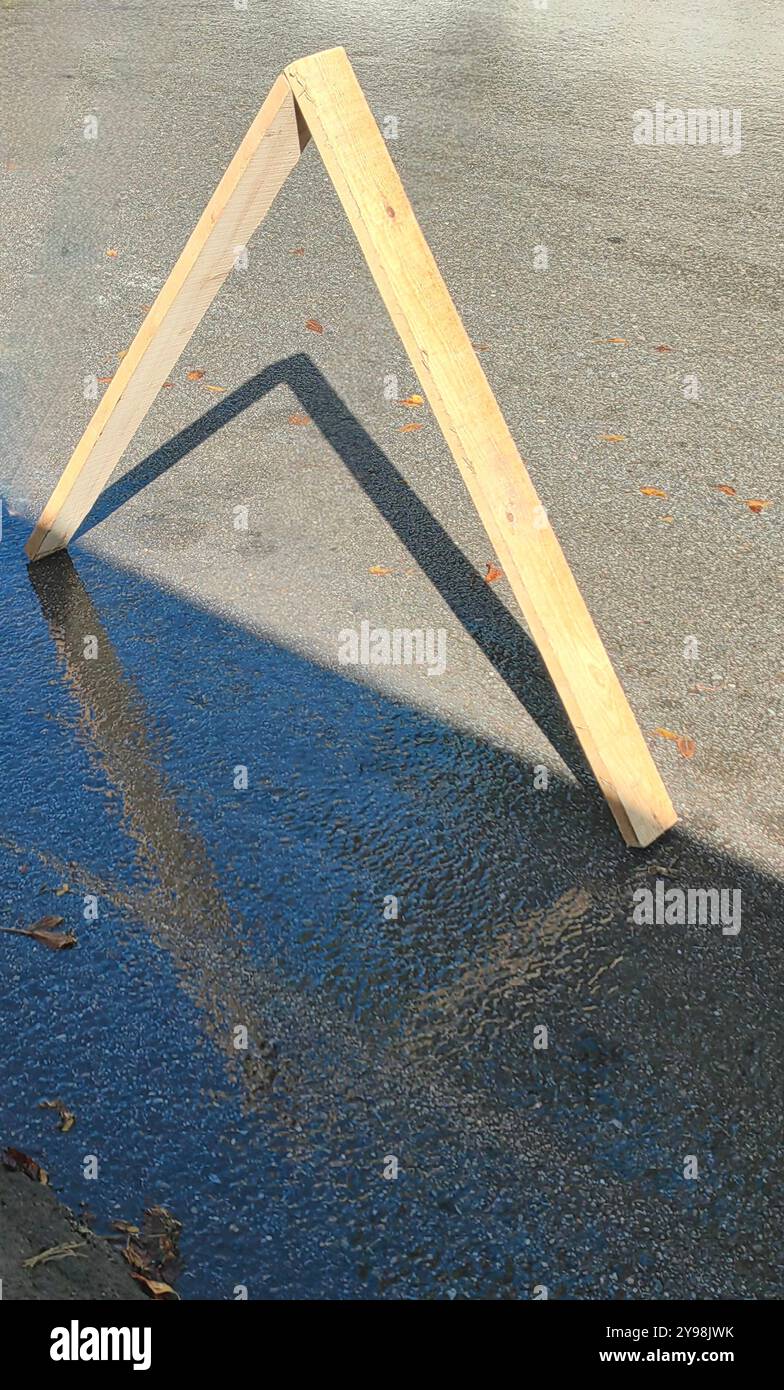 Triangolo riflesso delle tavole di legno su Wet Street - area parcheggio estetica Foto Stock