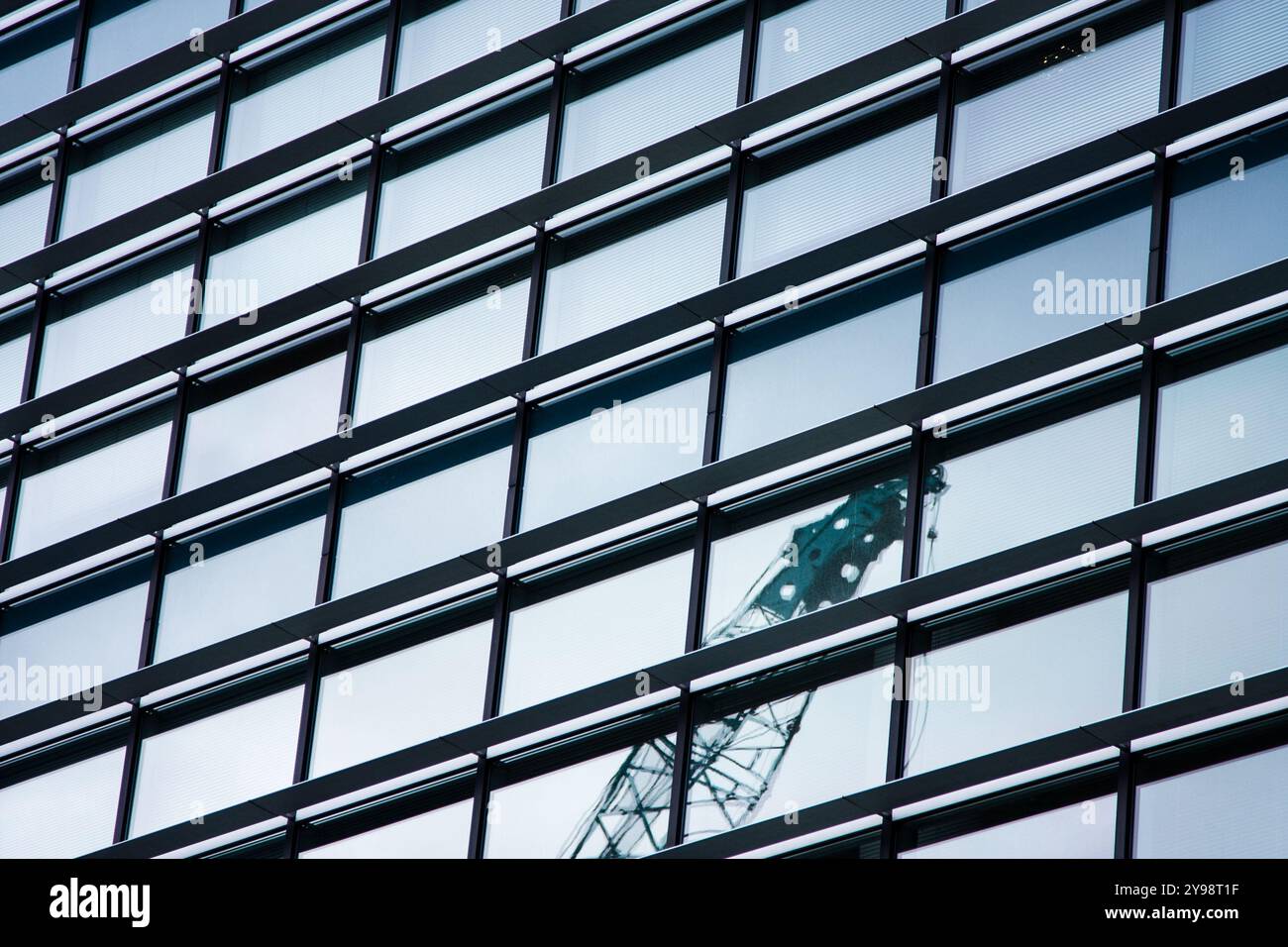 Astratto di un edificio con facciata in vetro con riflesso parziale di una gru, lungo il Clyde, Glasgow, Scozia Foto Stock