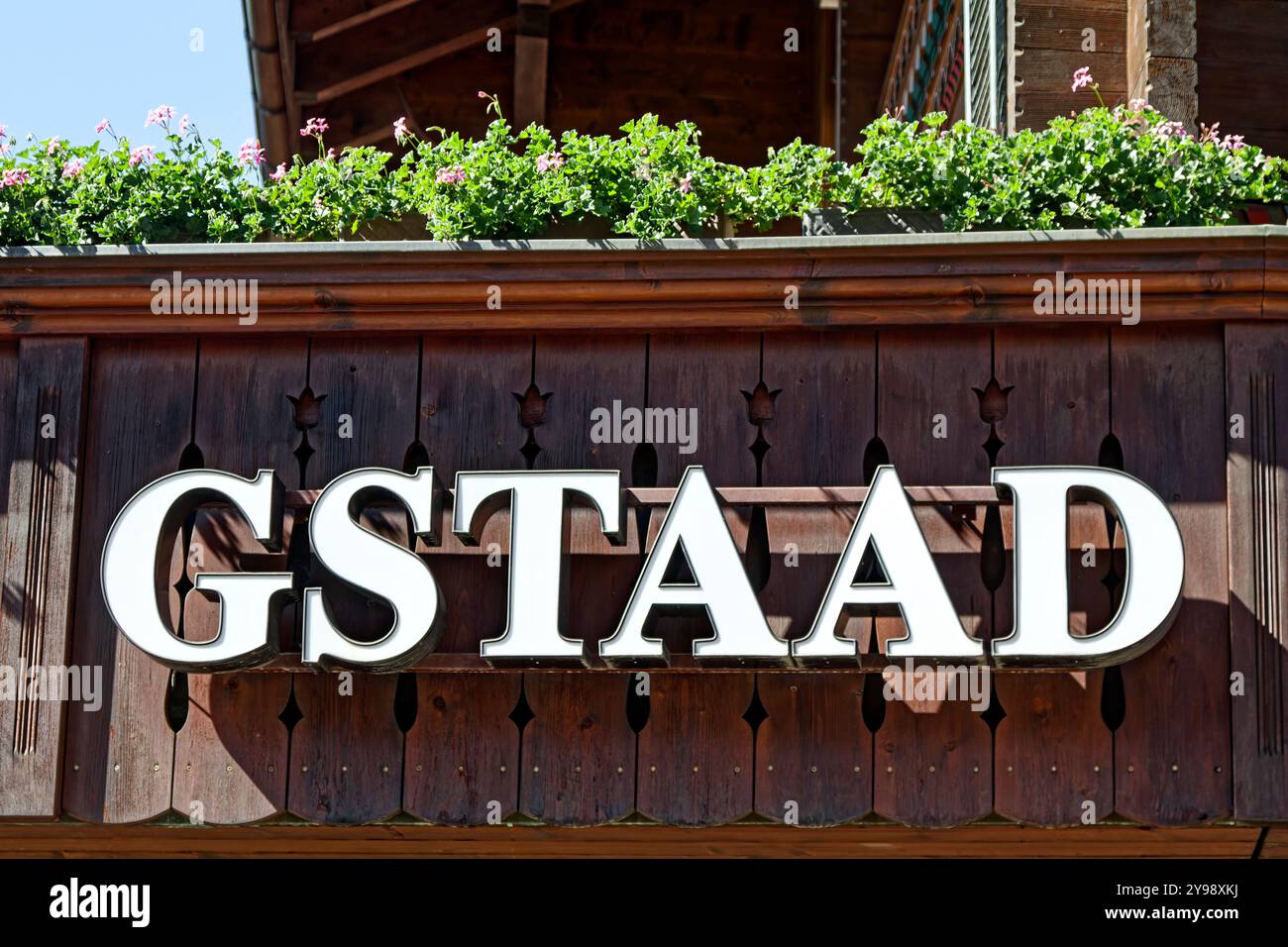 Segno Gstaad, moderno, lettere bianche, contorno nero, grande, Flowers Above, Wood building, Europe, Gstaad, Svizzera, estate Foto Stock