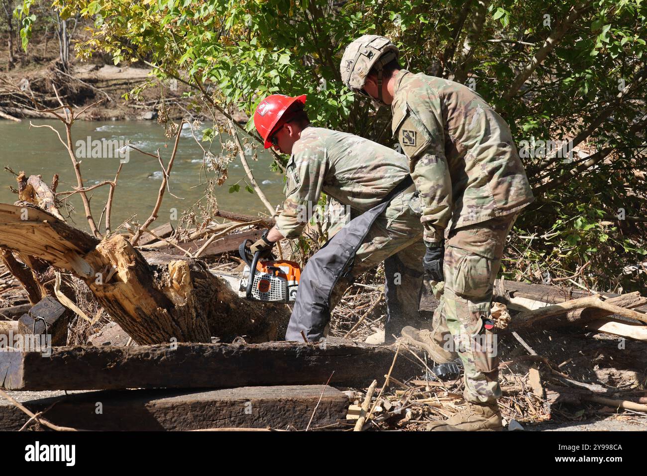 Toecane, Stati Uniti. 10 agosto 2024. I soldati dell'esercito americano, assegnati al 27th Engineer Battalion, usano una motosega per rimuovere i detriti in seguito alle inondazioni causate dall'uragano Helene, 8 ottobre 2024 a Toecane, Carolina del Nord. Credito: SSgt. Arthur Ruepong/US Army/Alamy Live News Foto Stock