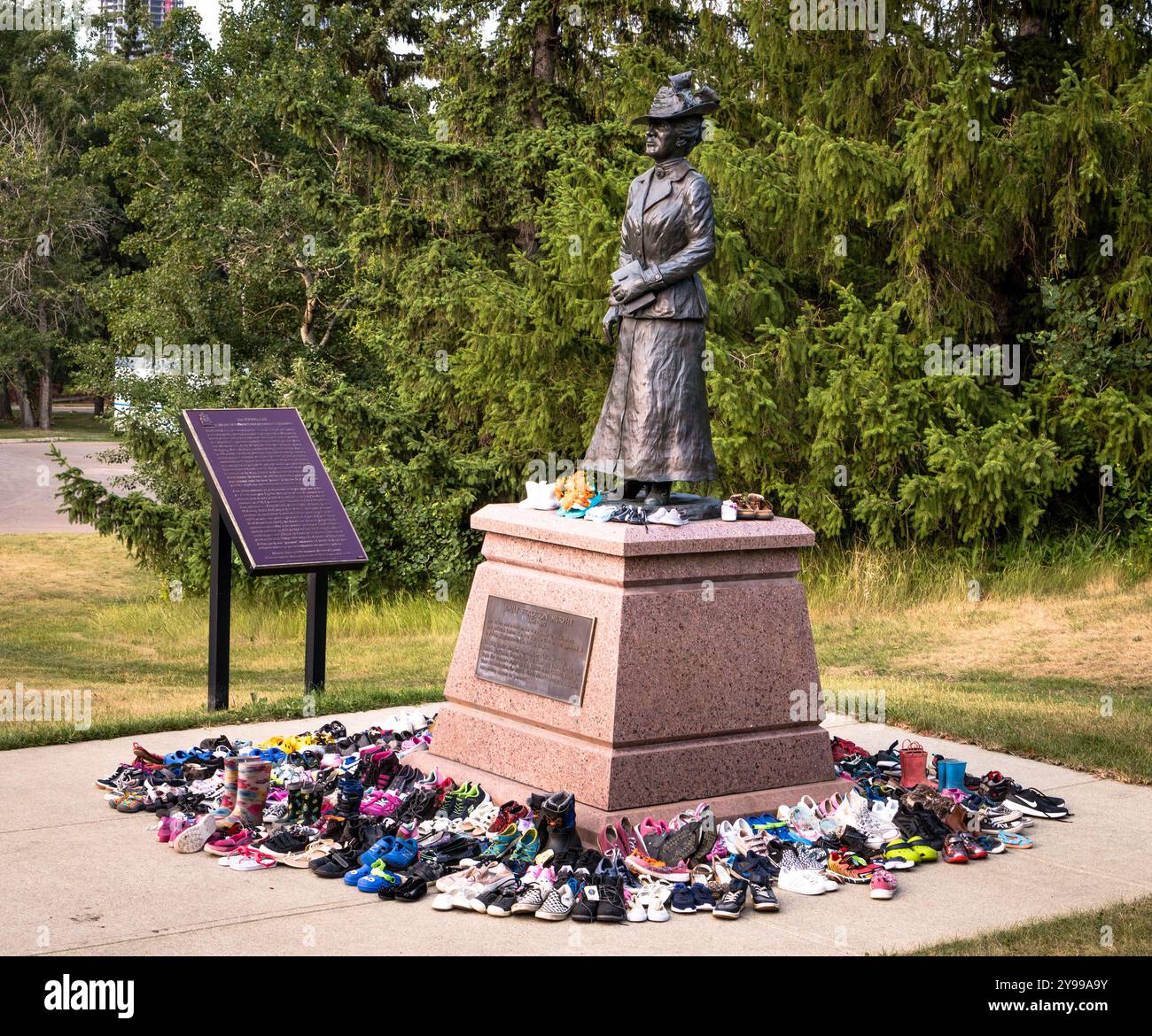 Edmonton, Canada, 30 luglio 2021: Scarpe per bambini sono state posizionate intorno alla base della statua di Emily Murphy nel parco della valle del fiume Foto Stock
