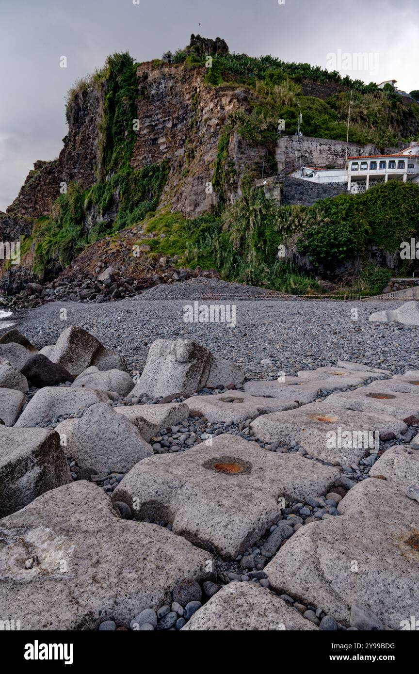 Costa rocciosa che conduce a torreggianti scogliere ricoperte di vegetazione lungo la costa di madeira Foto Stock