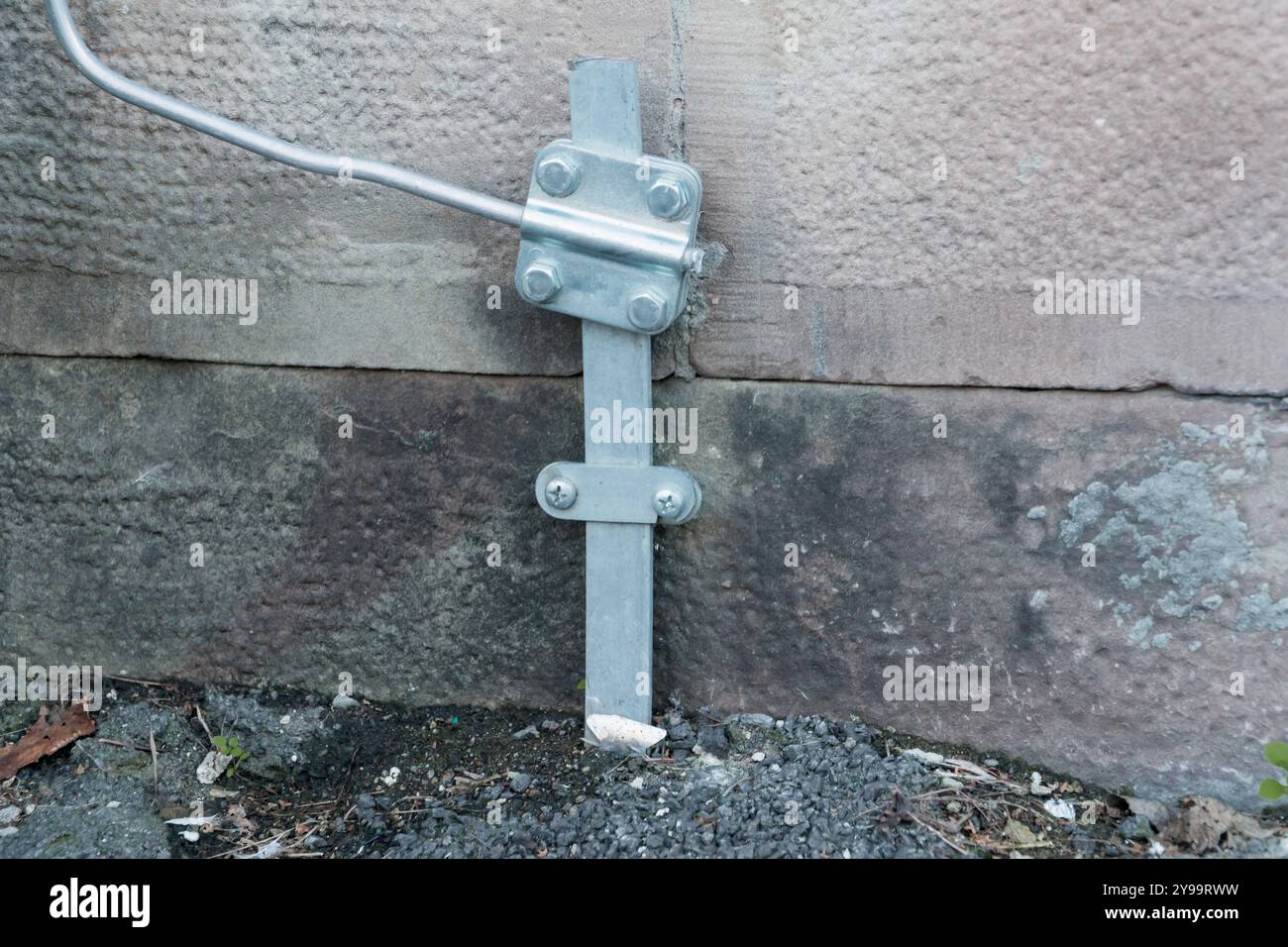 Staffa in metallo ancorata alla parete in calcestruzzo con bulloni e asta di supporto. Foto Stock